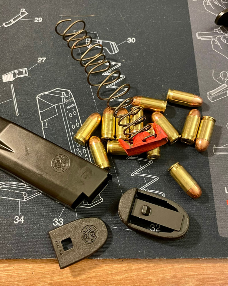 Disassembled Bodyguard 2.0 magazine and a pile of FMJ bullets on a gun-cleaning mat.